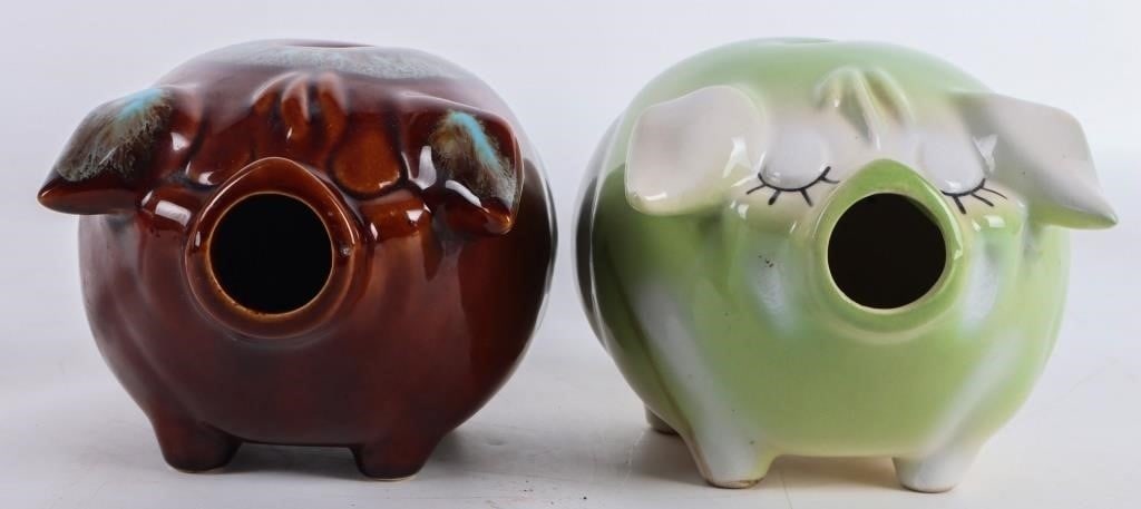 VINTAGE 1957 GREEN HULL 'CORKY PIG' BANKS - (2): Vintage 1957 Green Hull Pottery "Corky Pig" Banks to include one green/ white piggy bank, and one blue/ caramel piggy bank. Both do not have the original corks. Size: 7.00" X 5.00" Condition: No cork.