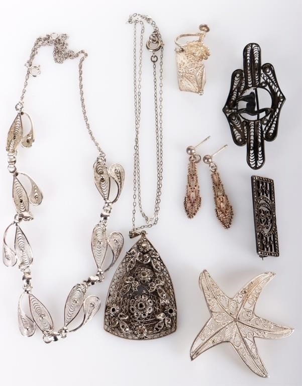 FILIGREE STERLING SILVER LADIES JEWELRY (7): Sterling silver filigree ladies jewelry lot. To include a brooch in the shape of a starfish, a brooch with an alpaca, a brooch with the initials CS and studded with spinel, an earring in the shape of 