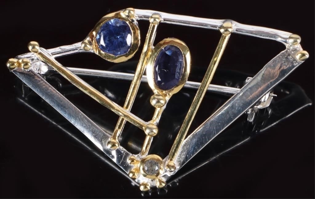 STERLING SILVER LADIES BROOCH W/ TOPAZ IOLITE MORE: Sterling silver ladies brooch molded in an abstract latticework. Includes a white topaz gem at the top, an iolite gemstone toward the middle, and a kyanite gemstone toward the bottom. Stone Type: Topa