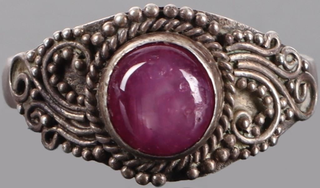 STERLING SILVER LADIES RING W/ RUTILATED RUBY GEM: Sterling silver ladies ring with an approximately 1.25ct round cabochon mildly rutilated ruby center gemstone. The fine detailing around the center stone resembles filigree. Stone Type: Ruby Size: US 