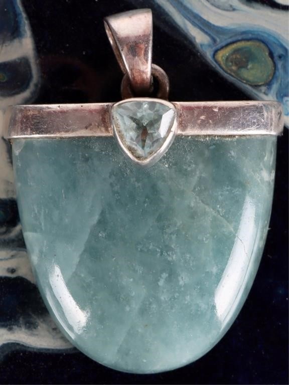 STERLING SILVER LADIES PENDANT W TOPAZ & BLUE JADE: Sterling silver ladies pendant with an approximately 0.75ct trillion-cut topaz gemstone and a large (26x8 23 mm) half-elliptical blue jade gemstone set beneath it. Stone Type: Topaz & Jade Size: 38 x 
