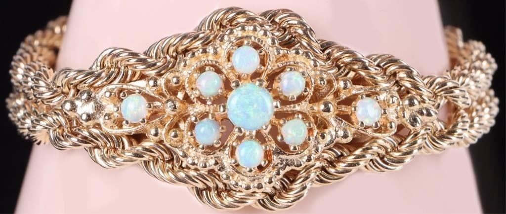 14K YELLOW GOLD OPAL CLUSTER DOUBLE ROPE BRACELET: 14K yellow gold opal cluster double rope chain ladies bracelet. Gemstones to include one 0.33ct round cabochon opal, and eight 0.07ct round cabochon opal. Stone Type: Opal Weight: 29.78 Grams Size: 6.