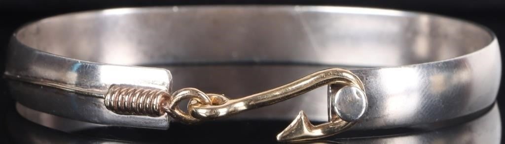 14K YELLOW GOLD ON 925 FISH HOOK LADIES BRACELET: Sterling silver ladies bracelet with a 14k yellow gold wash on a fishing line and hook design. The hook serves as the piece's clasp. Weight: 19.33 grams Size: 2.5" diameter Condition: See pictures.