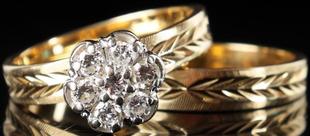 14K LADIES DIAMOND CLUSTER WEDDING SET: 14K yellow gold ladies diamond cluster wedding set. The bands are etched with a leaf design adding an elegant touch. Stone Type: Diamond Weight: 5.96 Grams Size: US 6.0 Condition: Slight surface scrat