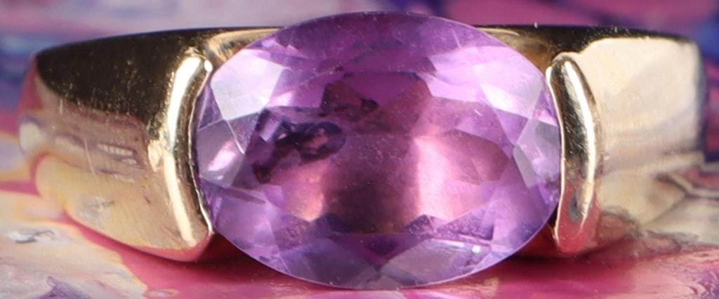 VINTAGE 10K GOLD AMETHYST OVAL CUT RING: Vintage 10 karat Gold Amethyst Tension-Set Ring. This striking estate piece features a modern, architectural design that highlights the natural beauty of the center stone through minimalist setting. S