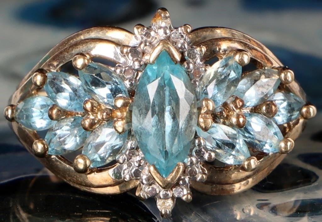 10K YELLOW GOLD BLUE TOPAZ DIAMOND LADIES RING: 10K yellow gold blue topaz diamond ladies ring. Gemstones to include one 0.50ct marquise cut blue topaz, twelve 0.03ct marquise cut blue topaz, and two 0.005ct round cut diamonds. Stone Type: Assorted