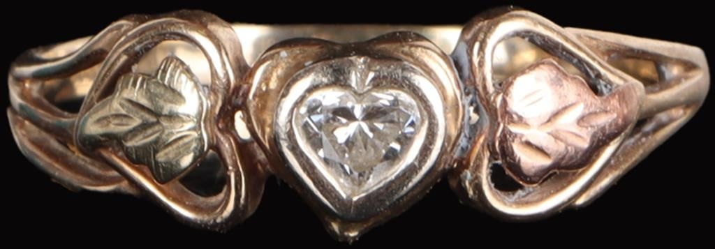 10K YELLOW GOLD LADIES RING W/ HEART DIAMOND: 10k yellow gold ladies ring with a 0.1ct heart-cut center diamond flanked by two moulded leaves, one rose gold and one yellow gold. Stone Type: Diamond Weight: 2 grams Size: US 8.5 Condition: See pict