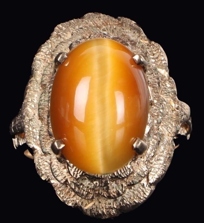 10K YELLOW GOLD TIGERS EYE LADIES RING: 10K yellow gold tiger's eye ladies ring. Gemstones to include one 13.97mm X 10.07mm cabochon tiger's eye. Stone Type: Tigers Eye Weight: 6.21 Grams Size: 5.00 U.S. Condition: Center stone is slightly 