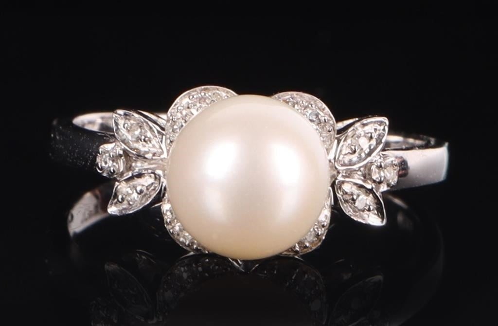 10K WHITE GOLD LADIES RING W/ DIAMONDS & 8MM PEARL: 10k white gold ladies ring with an 8mm diameter center surrounded by eighteen melee diamonds set on a leafy floral pattern on the face and shoulders. Stone Type: Diamonds & Pearl Weight: 2.75 grams Si