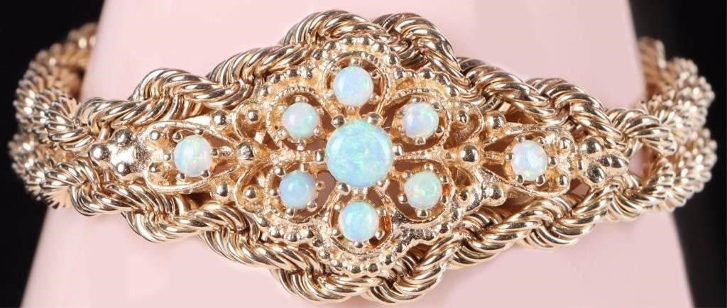 14K YELLOW GOLD OPAL CLUSTER DOUBLE ROPE BRACELET: 14K yellow gold opal cluster double rope chain ladies bracelet. Gemstones to include one 0.33ct round cabochon opal, and eight 0.07ct round cabochon opal. Stone Type: Opal Weight: 29.78 Grams Size: 6.