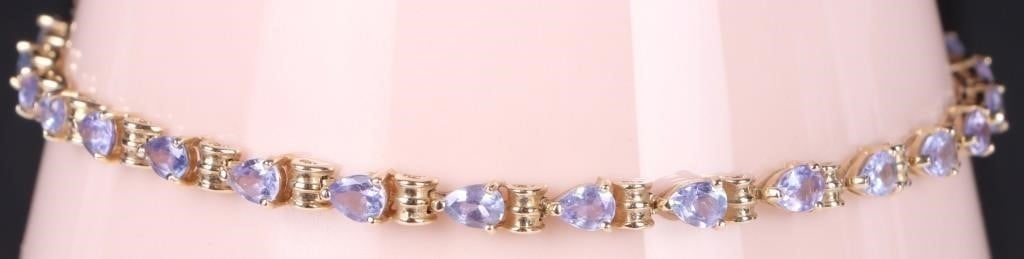 PURPLE IOLITE 14K YELLOW GOLD LADIES BRACELET: Purple iolite 14K yellow gold ladies tennis bracelet with twenty-seven 0.15CT pear shaped iolite. Weight: 6.55 Grams Size: 8.0" length Condition: Slight wear, see images.
