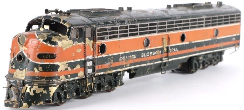VINTAGE O GAUGE BRASS MODEL TRAIN EMD E8/9A CUSTOM: Vintage O gauge brass model train of the General Motors EMD E8/9A model. The piece features a custom paint job resembling a Northern Pacific design, albeit with a fictional 'Orange Blossom Trail' line