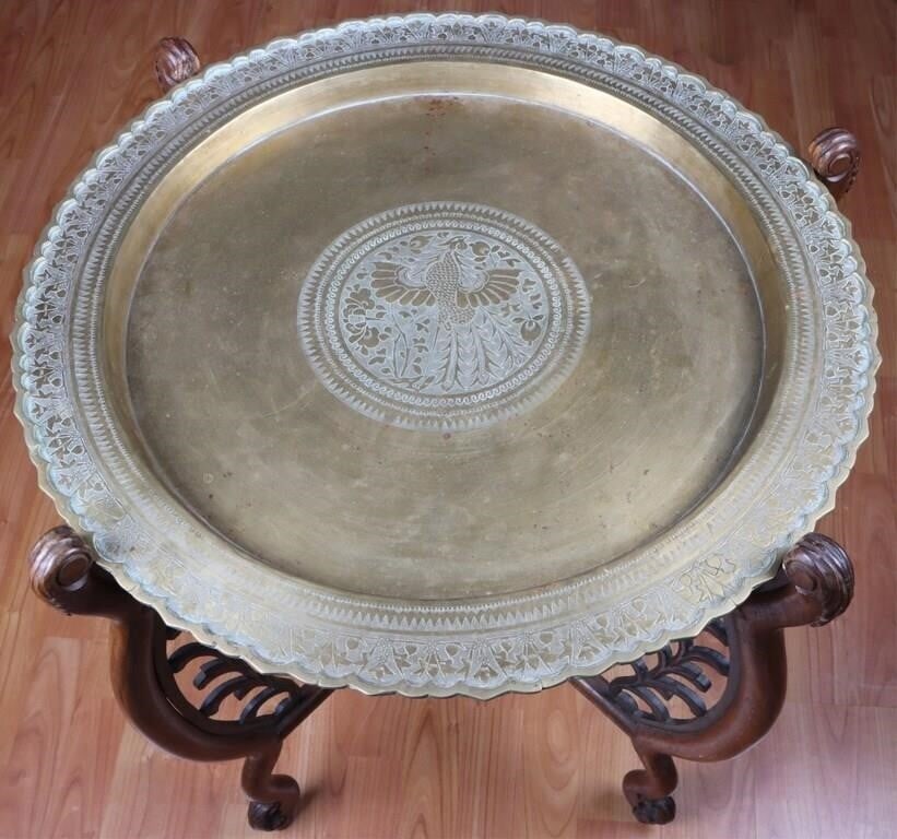 VINTAGE BRASS BIRD & FLOWER CARVED TRAY TABLE: Vintage brass bird & flower carved tray table wooden base. The tray includes a beautiful carved bird & flower design inside the middle of the plate. Size: 27.00" X 26.50" Condition: Wear commensurate 