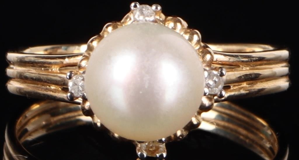 14K YELLOW GOLD LADIES RING W/ PEARL & DIAMONDS: 14k yellow gold ladies ring with a 7.6mm diameter genuine white round pearl and four small diamonds positioned on each end of the pearl. The areas around the diamonds are white gold. Stone Type: Diamo