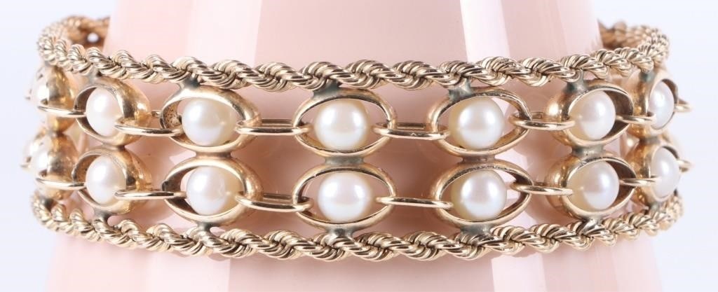 14K YELLOW GOLD LADIES BRACELET W/ 28 ROUND PEARLS: 14k yellow gold ladies bracelet. The piece consists of two exterior rows of braided chains with two interior chains between them in an alternating pattern of thick and thin links. Within each thick li