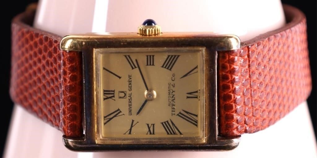 18K GOLD TIFFANY & CO AUTOMATIC LIZARD STRAP WATCH: Universal Geneve Tiffany & Co 18k yellow gold tank style automatic genuine lizard strap watch with sapphire crown. Yellow Gold Wristwatch Tiffany Ladies Weight: 23.0 Grams Size: 20mm Condition: Minor 