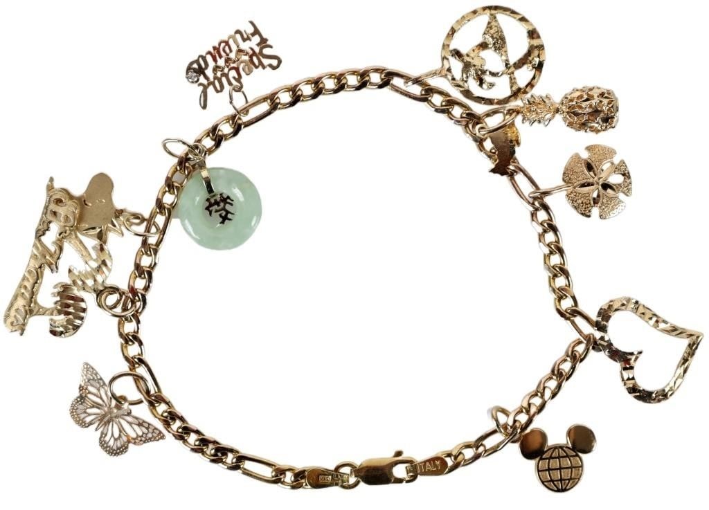 14K YELLOW GOLD CHARM BRACELET W/ JADE: 14K yellow gold ladies charm bracelet with eleven charms, to include an Epcot logo, a stylized heart, a sand dollar, a pineapple, a fish with 'Hawaii' etched on its surface, a couple palm trees surrou