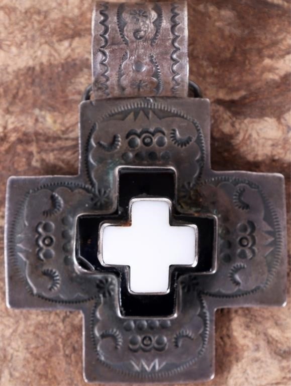 DAN DODSON SANTA FE STERLING CROSS PENDANT: Dan Dodson Santa Fe sterling silver cross pendant featuring hand stamped silver with onyx and agate inlay. Stone Type: Onyx Weight: 54.28 Grams Size: 3.75" x 2" x 0.5" Condition: Small chip in the cor
