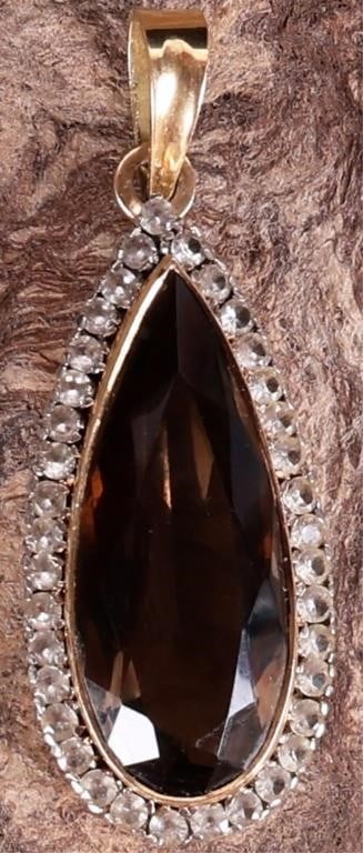 14K YELLOW GOLD LADIES SMOKY QUARTZ PENDANT: 14K yellow & white gold ladies pendant with an approximately 19.5ct pear-cut smoky quartz center gemstone surrounded by thirty-seven 0.05ct round-cut white quartz gemstones. The setting around the spi