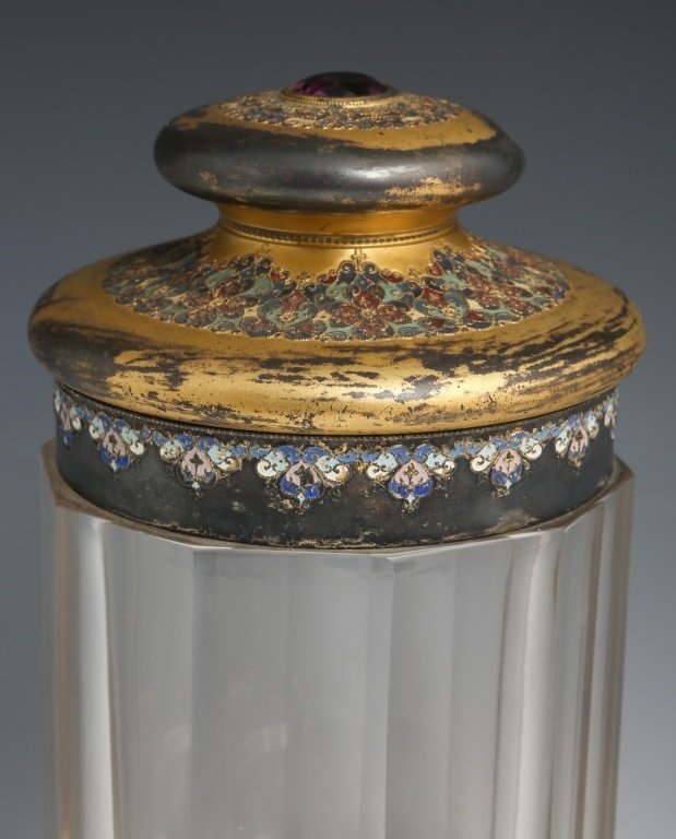 ENAMELED METAL & GLASS HUMIDOR: ENAMELED METAL & GLASS HUMIDOR Glass jar humidor with intricately enameled details; studded with faceted purple stone in lid. Unmarked. Size: 9 x 5.25" Shipping / Pickup: We Can Ship This Item Lot Loc