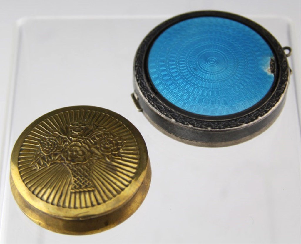 (2) ANTIQUE MAKE UP COMPACTS: (2) ANTIQUE MAKE UP COMPACTS Lot of two antique compacts. Includes (1) sterling silver with enamel lid, and (1) brass. Weight: 58.7g total Shipping / Pickup: We Can Ship This Item Lot Location: #1 - C