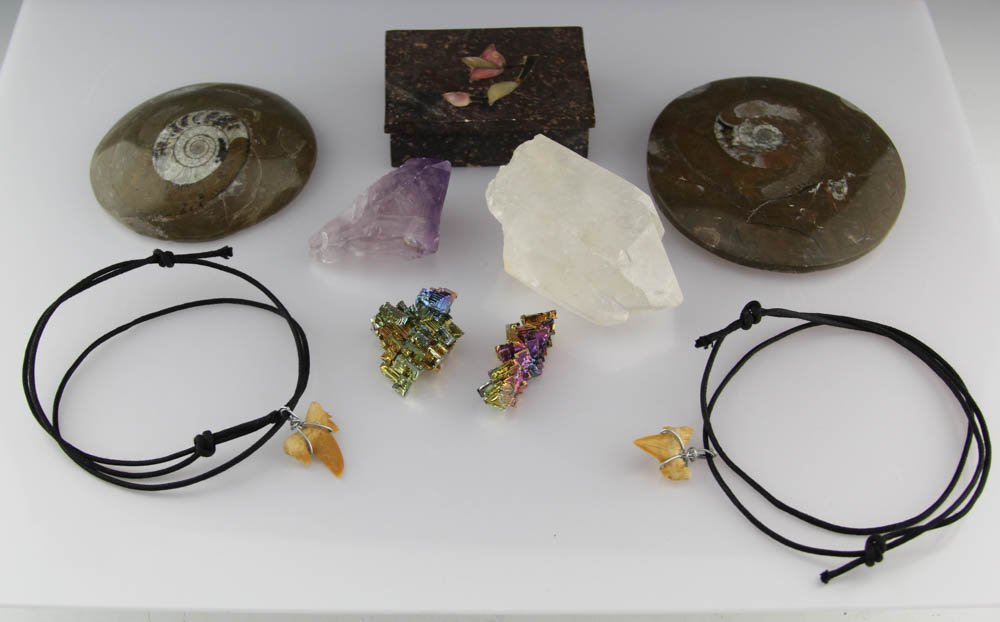 MIXED LOT FOSSIL, CRYSTAL & SHARK TEETH: MIXED LOT FOSSIL, CRYSTAL & SHARK TEETH To include (2) ammonite fossils, (1) amethyst crystal, (2) bismuth crystals, (2) shark teeth necklaces, (1) quartz crystal, and (1) stone trinket box. Shipping