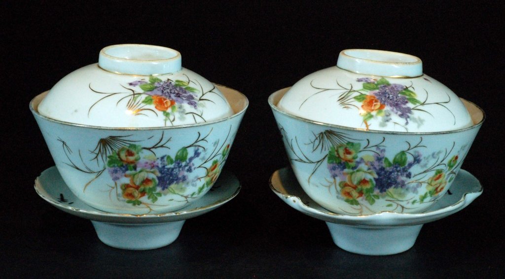 Pair of Famille Rose Covered Teacups & Saucers: Republic Period, each famille rose porcelain covered tea cup with painted floral sprays and parcel gilt decoration, marked to base and cover, and raised on the fitted saucer. Size : 4" H each, includi