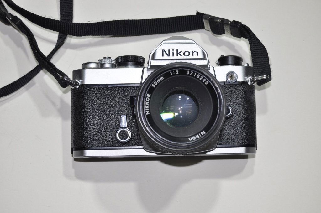 Nikon FE SLR Camera: A Nikon FE single-lens reflex camera with chrome body.