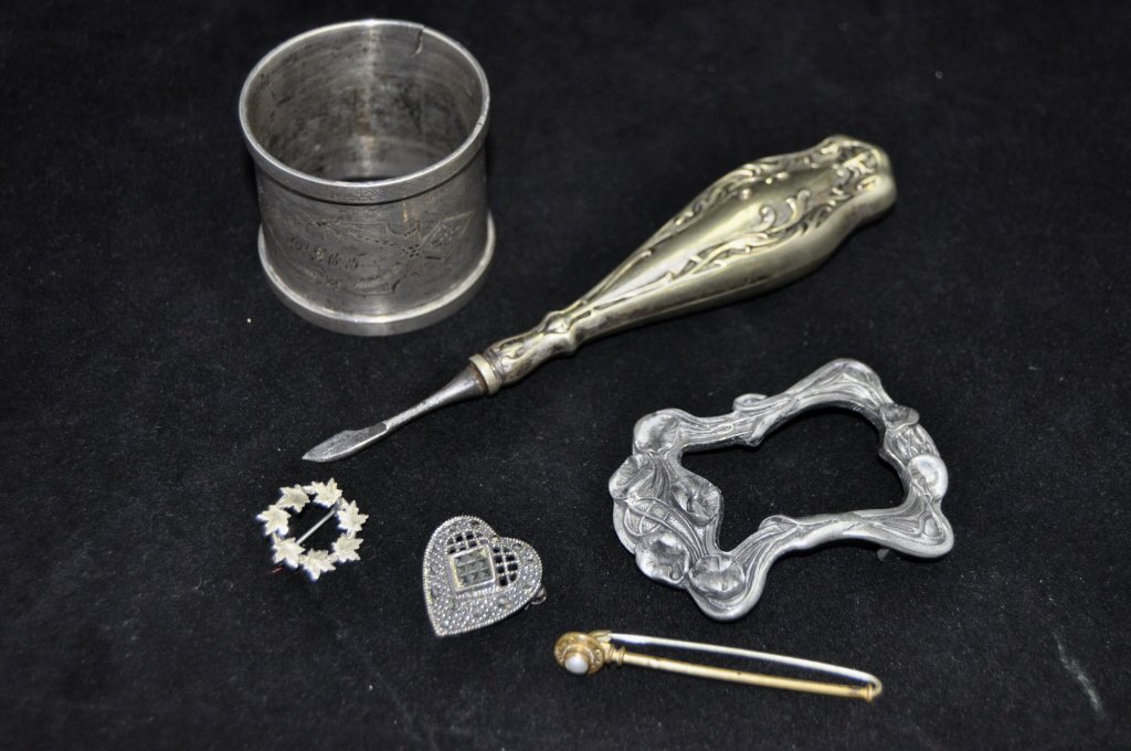 Six Assorted Estate Items: Comprising three jewelry articles, a silver napkin ring, a pewter Art Nouveau frame, and one additional example.