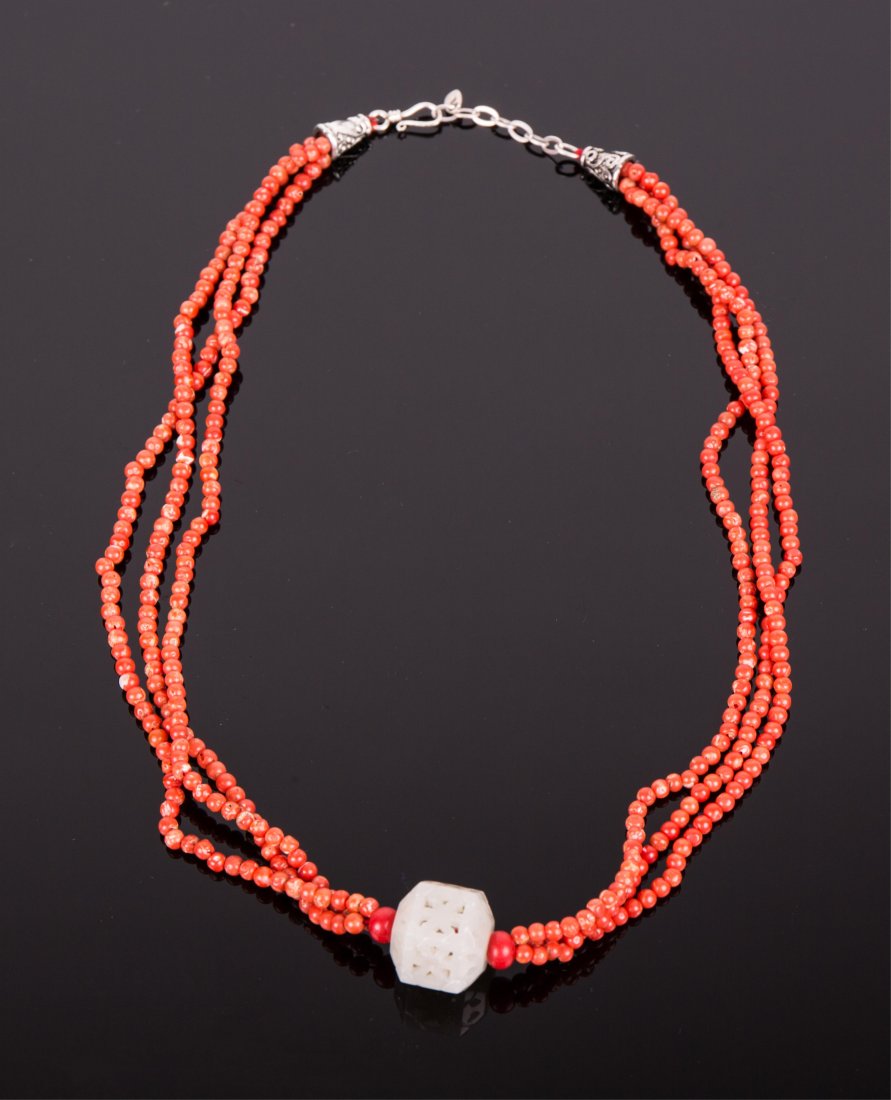 CORAL BEADS AND WHITE JADE NECKLACE: Qing dynasty; coral beads necklace enter by an hexagonal white jade beads carved in open work; white jade pendant; 16 7/8 in. l