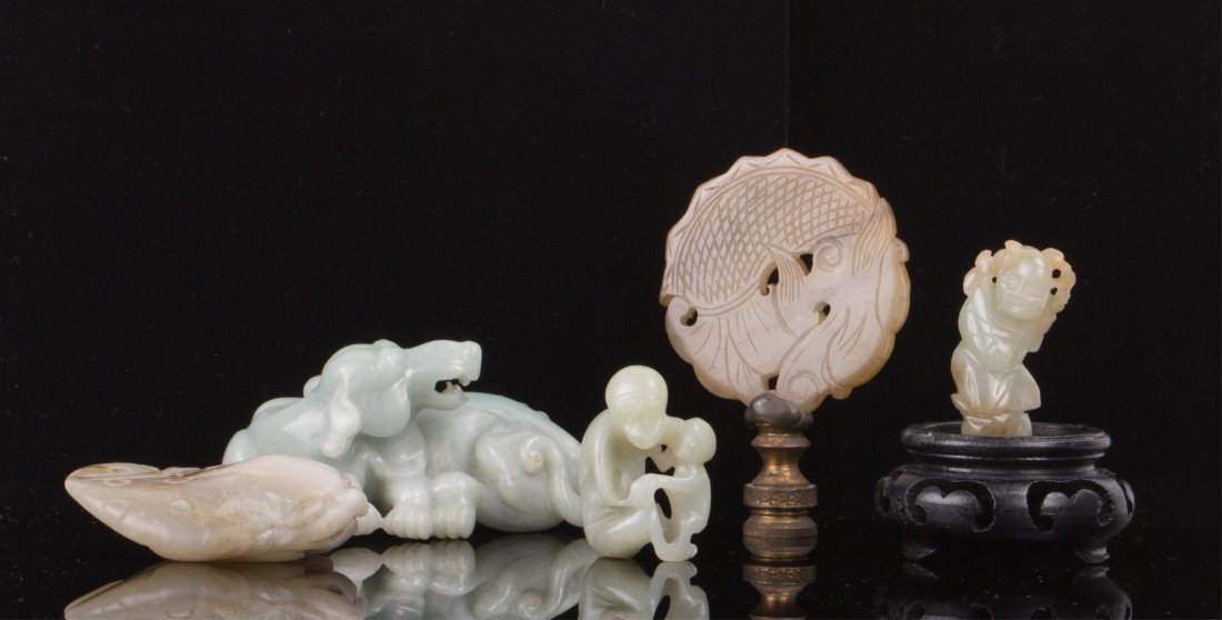 FIVE CHINESE JADE ARTICLES: 19th / 20th century; one dog, one toad, one monkey, one boy and one fish pendant; largest (3 in. h, 2 in. w), smallest (1 1/2 in. h, 1 in. w)