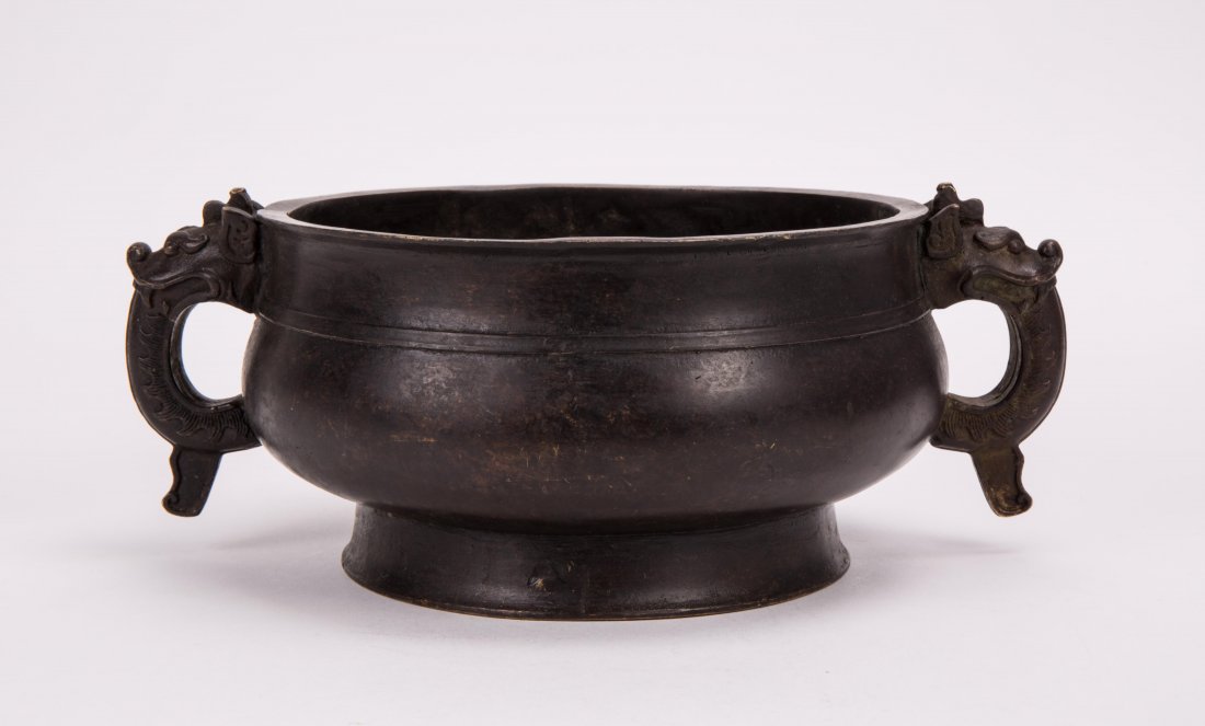 CHINESE HEAVY BRONZE CENSER WITH ARCHIAC HANDLE: 19th century or earlier, body with rib design; 3 3/4 in. h, 10 in. w