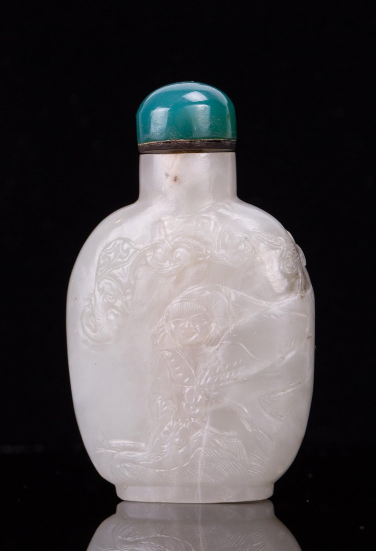 CELADON JADE SNUFF BOTTLE WITH LOUHAI MOTIF: 19th / 20th century; 2 3/4 in. h, 1 3/4 in. w