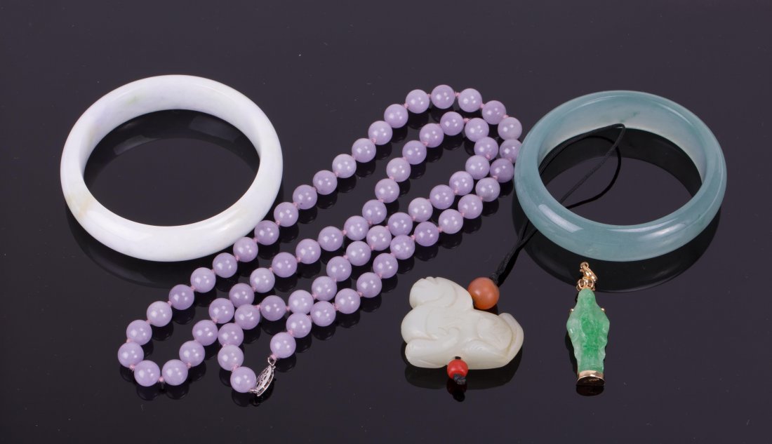 A GROUP OF FIVE JADE OR JADEITE JEWELRY: a white bangle, a greenish bangle, a purple beads necklace, a white jade beast pendant, a green jadeite Kuan Yin pendant. pendant (1 3/4 in. h), necklace (12 in. l)