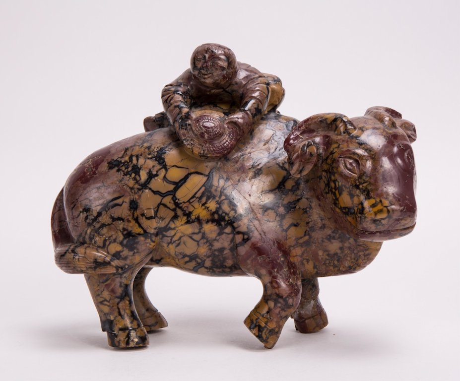 CHINESE CARVED HARDSTONE BOY RIDING OX: 20th century; 6 1/2 in. h, 8 in. w
