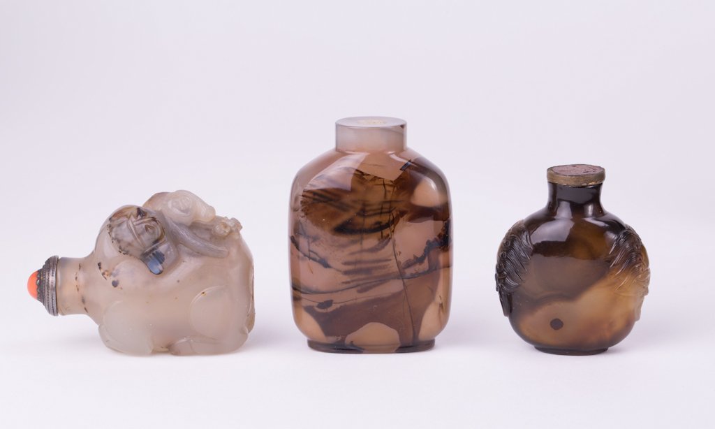 THREE CHINESE AGATE SNUFF BOTTLES: Qing dynasty; shortest (2 in. h), tallest (2 3/4 in. h)