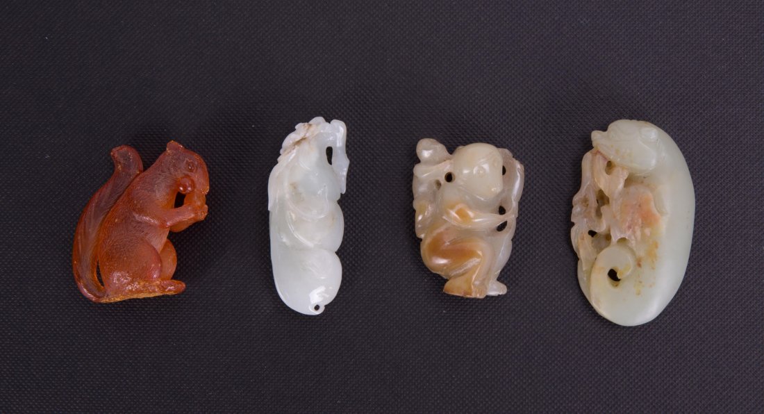 GROUP OF FOUR CHINESE CARVING - AMBER AND JADE: 19th cen, amber squirrels and jade boy, monkey, small chip on amber; smallest (1 1/2 by 1 1/8 in.), largest (2 by 1 1/8 in.)