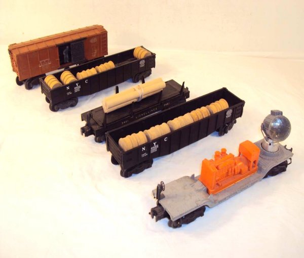 ABT: 5 Assorted Lionel Freight Cars: Paul V. Ambrose and Drew J. Bauer present: These are two #6464 Gondolas, the #3620 Searchlight, the #3461 Log Dump Car and the #3464 Operating Box Car that Lionel made in the 1950s. Please add $18.00 