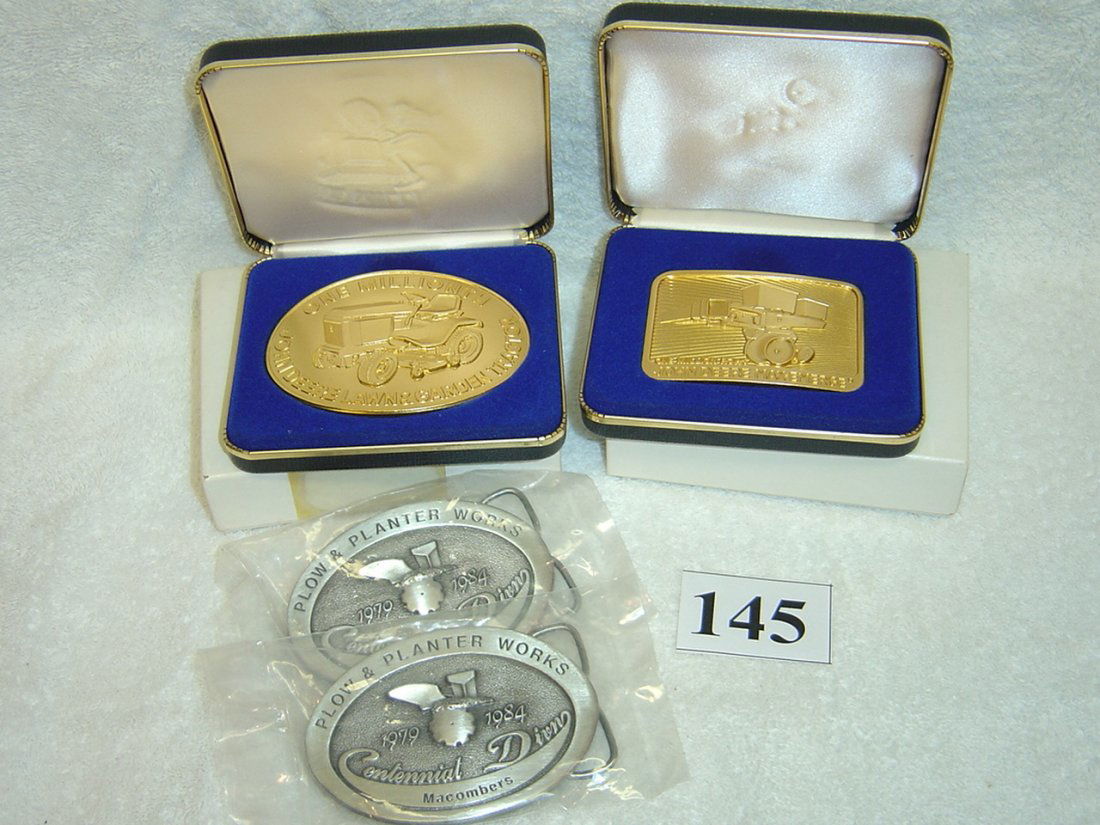 FOUR COLLECTIBLE JOHN DEERE BELT BUCKLES: PAIR SILVER TON PLOW AND PLANTER, 1984 I MILLIONTH MAX-EMERGE NO. 2542 AND 1984 I MILLIONTH LAWN AND GARDEN NO. 481.