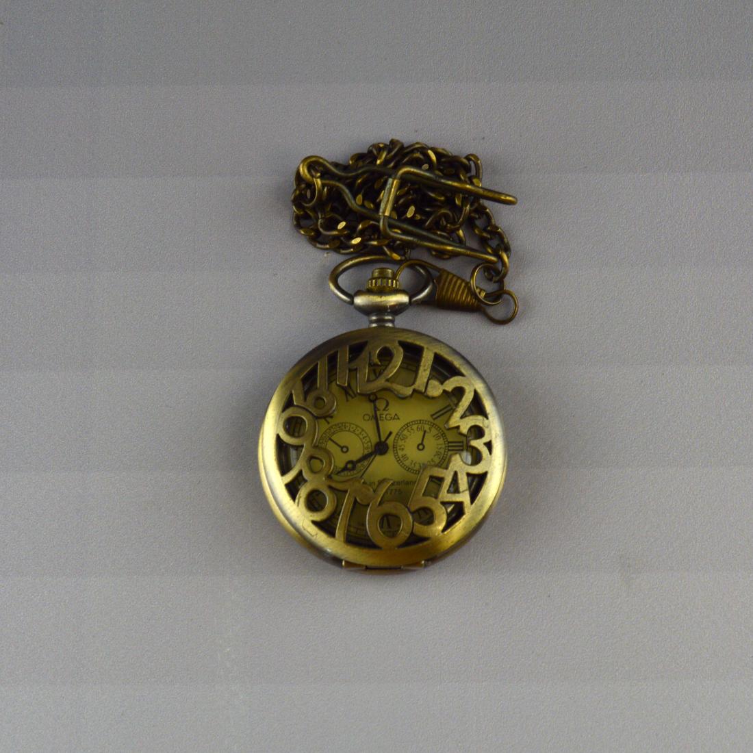 Omega Pocketwatch: An openwork Omega pocketwatch with intricately carved backing and an openwork cover H 2" W .375" L 15" Weight