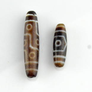 Dzi Bead Pair: 二顆天珠 2 Item Lot; a pair of dzi beads. One longer nine-eyed dzi bead and one shorter three-eyed dzi bead. Sizing:2.2 inches x 0.3 inches x 0.3 inches; Weight: 25g