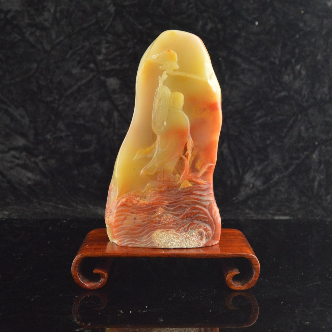 Soapstone Carved Figure Decor: 壽山石雕人物 A vibrant soapstone or 'Shoushan' stone carved piece depicting a figure on one side and a vibrant orange edging around the other side.Depicting a trave