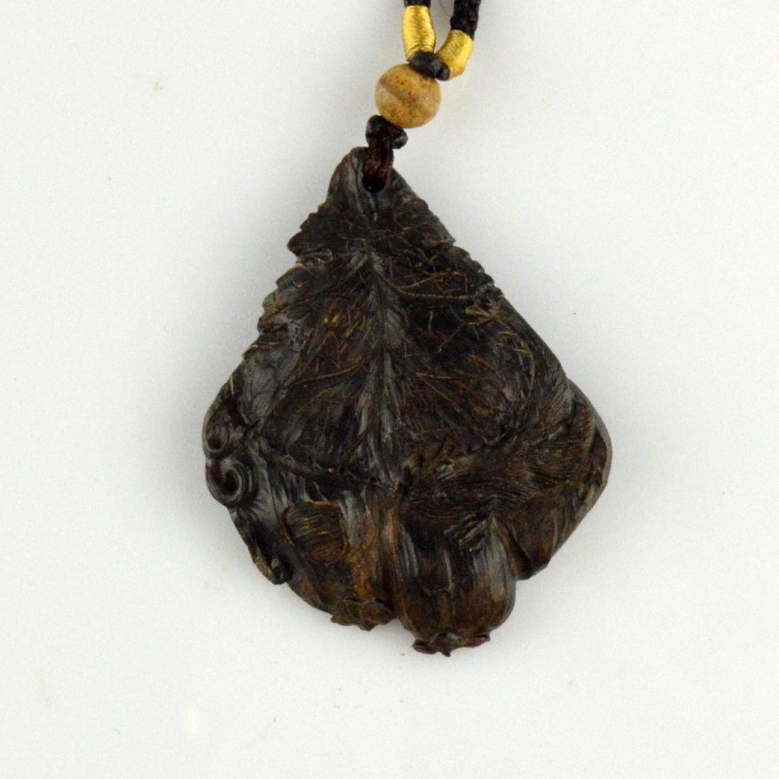 Natural Incense Wood Pendant Necklace: 天然沉香 A natural 'incense' or 'chenxiang' wood carved pendant with intricate detailing and strung on a woven necklace. Weight: 20
