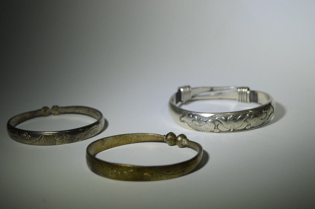 Set of Three Silver Bracelets: Set of 3 Silver Bracelets. One lightly etched, one depicting detailed fish, and one with floral design.