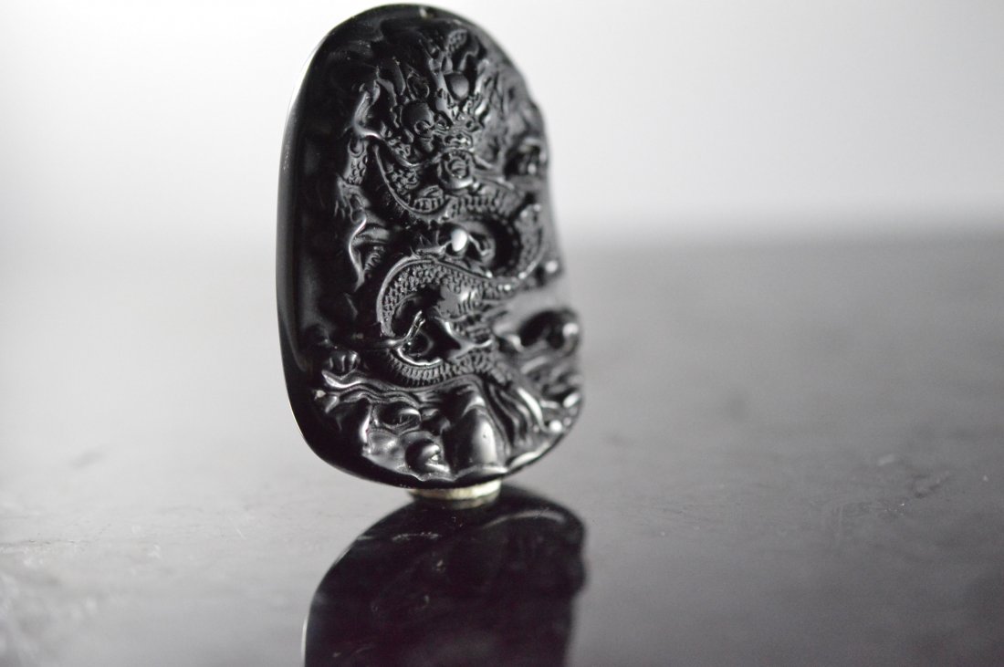 Obsidian Carved Pendant: An obsidian pendant carving dragon; meaning in control of everything L x 1.500" H x 2.125" W x 0.500"
