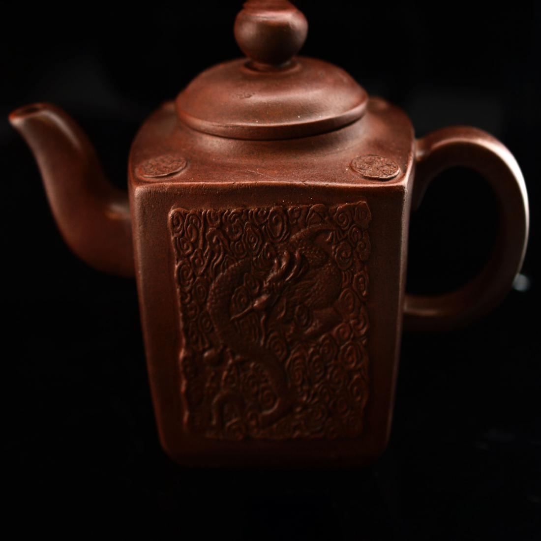 Marked Zi Sha Tea Pot: A tea pot made of Zi Sha; carving dragon on side; marked "Wu Yun Gen Zhi";-----Approx. Size: L x 6.500" W x 3.375" H x 4.875" 431.700g