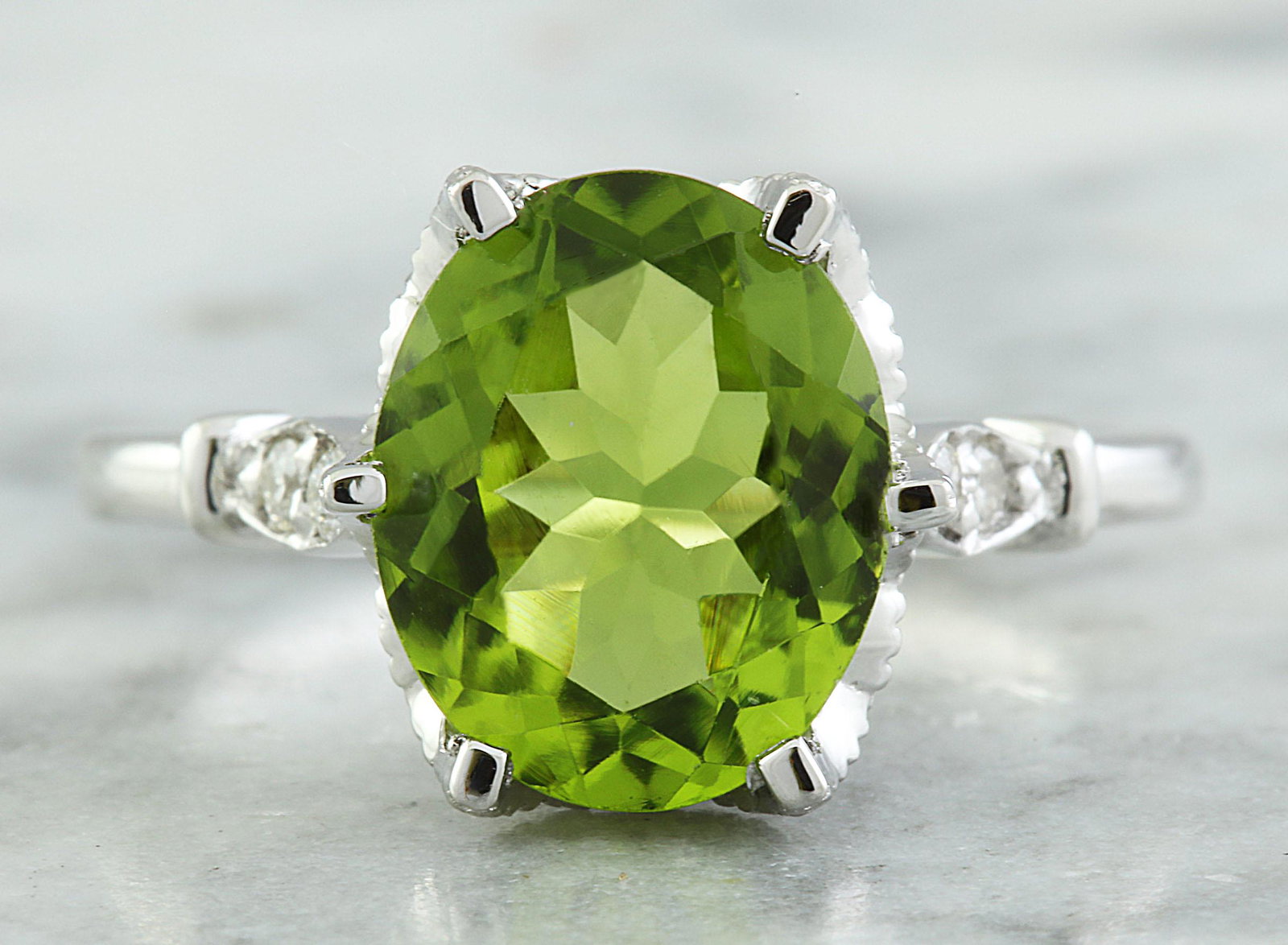 3.41 CTW Peridot 14K White Gold Diamond Ring: 3.41 CTW Peridot 14K White Gold Diamond Ring Manufacturer's Suggested Retail Price: $ 2600.00 Stamped: 14K Total Ring Weight: 4.2 Grams Peridot Weight: 3.26 Carat (11.00x9.00 Millimeters) Diamond Weig