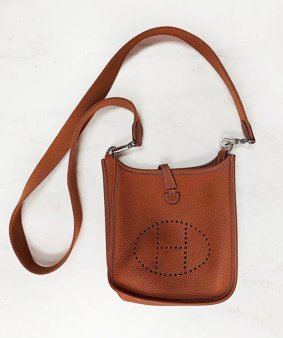HERMES Taurillon Clemence Evelyne TPM Bag: IMMEDIATE SHIPPING!This is an authentic HERMES Taurillon Clemence Evelyne TPM in Gold BagThis chic messenger bag in the smallest size is crafted of rich taurillon clemence calfskin leather in a golden