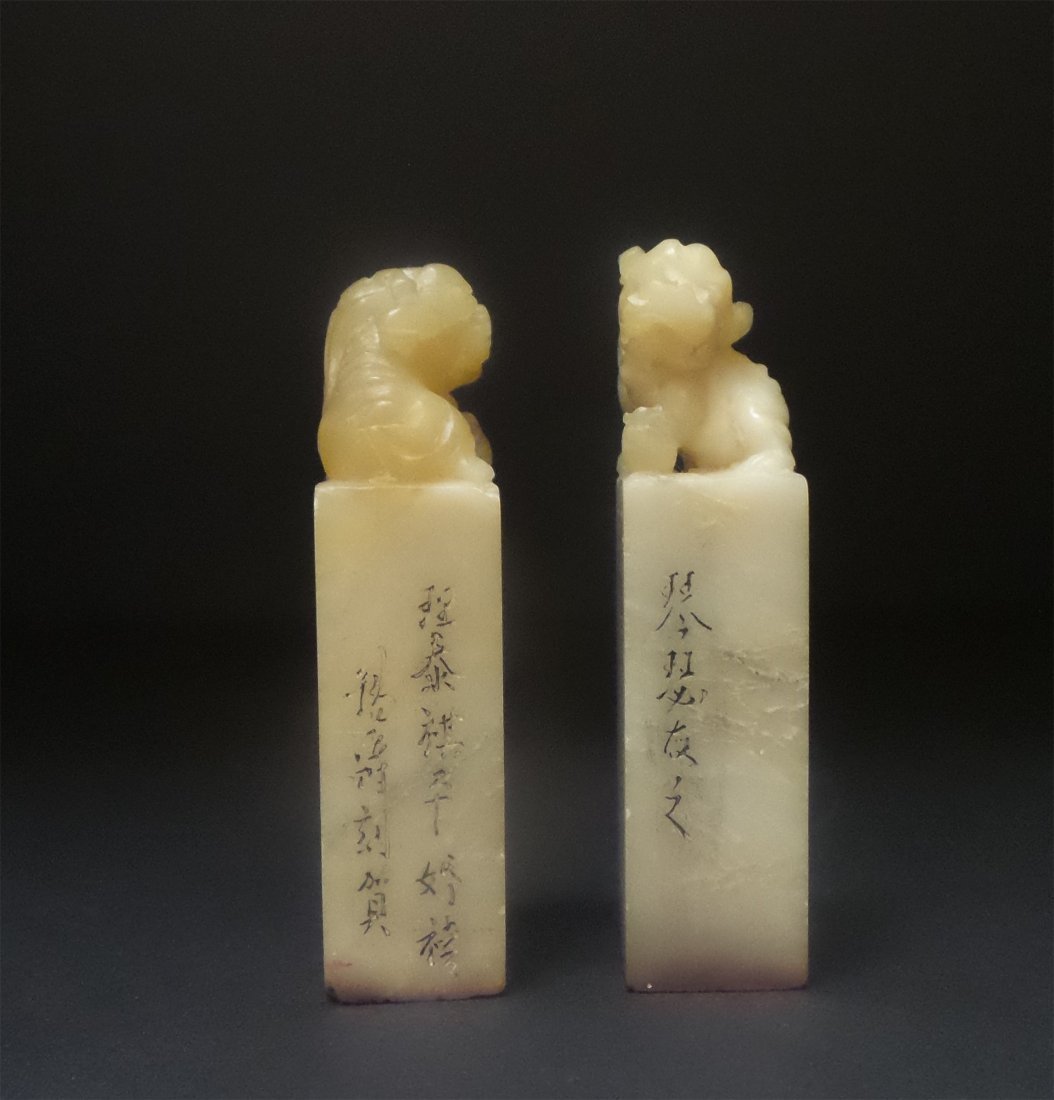 PAIR OF CHINESE CARVED SOAPSTONE LION SEALS: 清壽山石荔枝凍獅鈕印章。錫爵刻。钱锡爵，江苏省扬州
