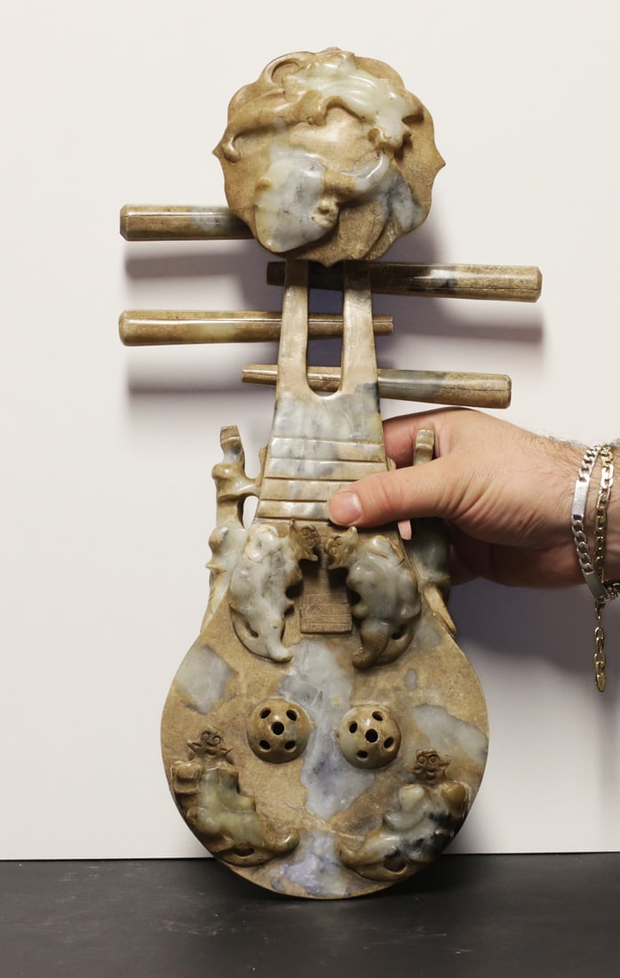 Impressive jade Pipa Lute 2,8 kg: China Empire. Qing dynasty. 1850 AD. Impressive jade Pipa (Chinese Lute ????) Statue. Extremely decorated and fine encarved. Fu dog on the top. Removable pegs. Extremely rare. 2,8 kg. - 39x15x8 cm. An